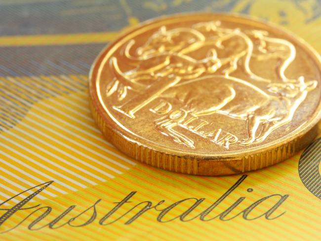 Australian one dollar coin on a fifty dollar note.  Close-up view, with shallow depth of field; generic money