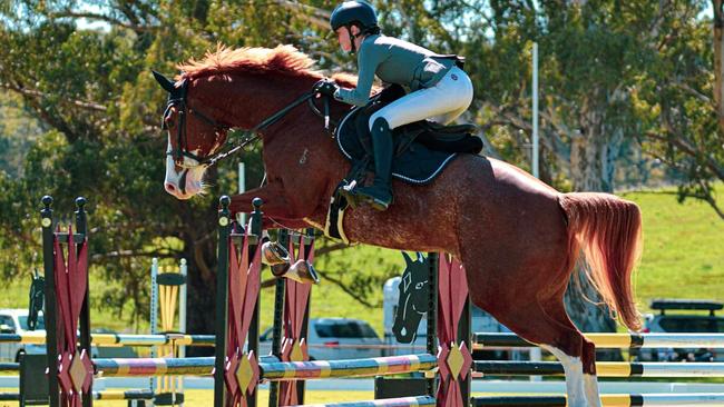 Holly Bolzon in action at a jumping event.