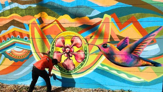 Art embraced ... an artists puts the finishing touches on a mural in the capital. Picture: Bogota Graffiti