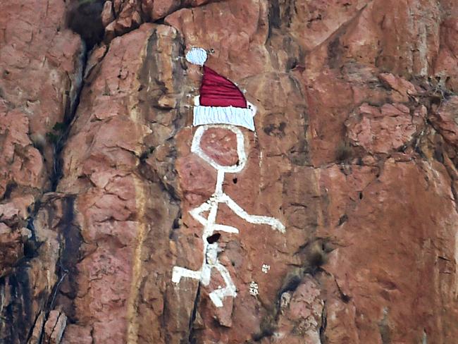 Townsville iconic Saint on Castle Hill has gotten into the Christmas spirit with the addition of a Santa hat. Picture: Alix Sweeney