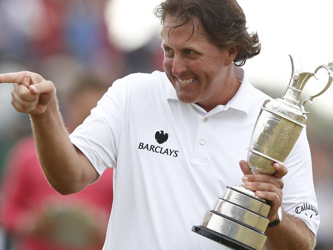 Phil Mickelson of the United States gestures as he holds the Claret Jug trophy after winning the British Open Golf Championship at Muirfield, Scotland, Sunday July 21, 2013. (AP Photo/Matt Dunham)