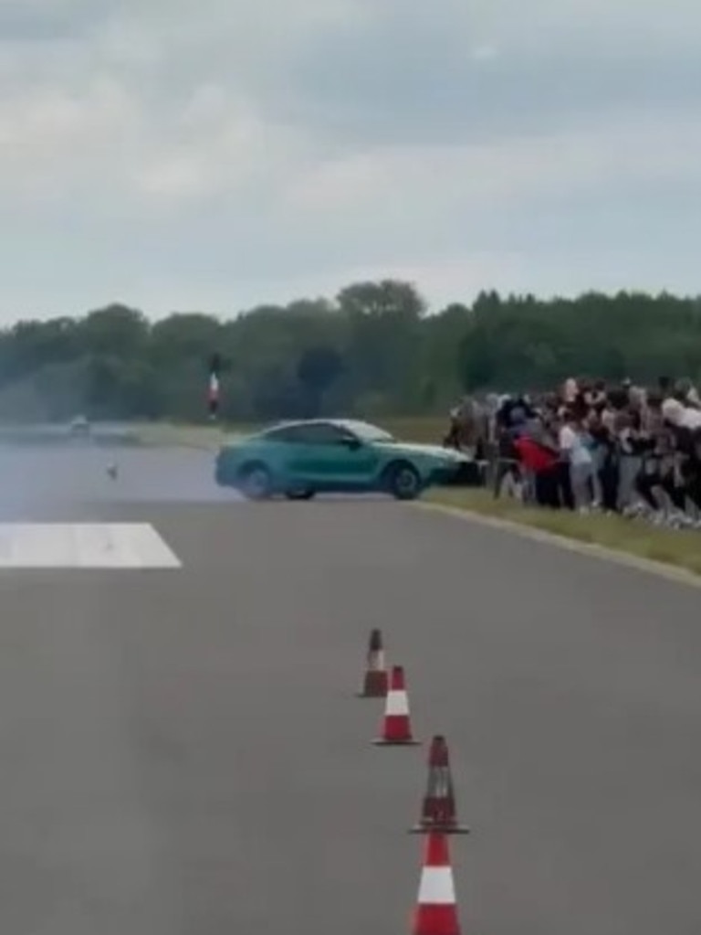 The car turns directly at the crowd.