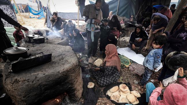 Palestinian women make break in ovens at a makeshift camp housing displaced Palestinians, in Rafah in the southern Gaza Strip. Photo: AFP