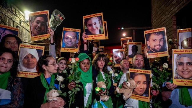 Families and friends who lost loved ones in the Grenfell Tower fire hold portraits of victims as they commemorate the tragedy. Picture: AFP