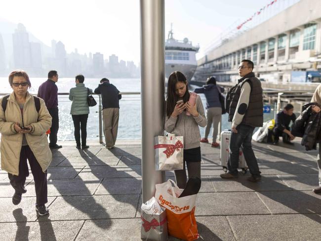 A woman uses her mobile phone and stands by her shopping bags on the Victoria Harbour waterfront in Hong Kong. ‘Bobbie’ has been an overwhelming success in China with a remarkable following.