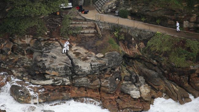 Police take to the rocks to search for a swimmer missing off Bondi in dangerous surf. Picture: Toby Zerna