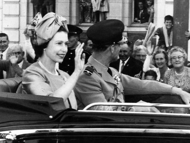 Queen Elizabeth II and tPrince Philip give a smile and wave to the crowd that saw their arrival Port Adelaide to join her “floating home”, the royal yacht Britannia.
