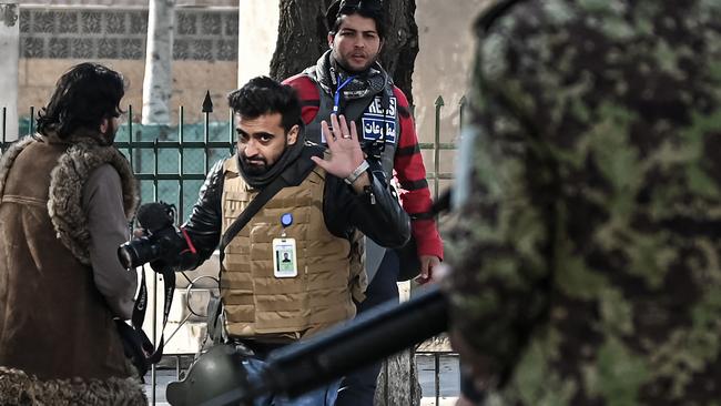 Taliban fighters walk toward journalists during a protest in Kabul. Picture: AFP.