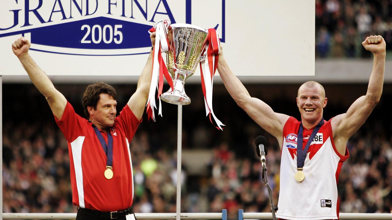 Former Sydney coach Paul Roos and Barry Hall raise the 2005 premiership cup.