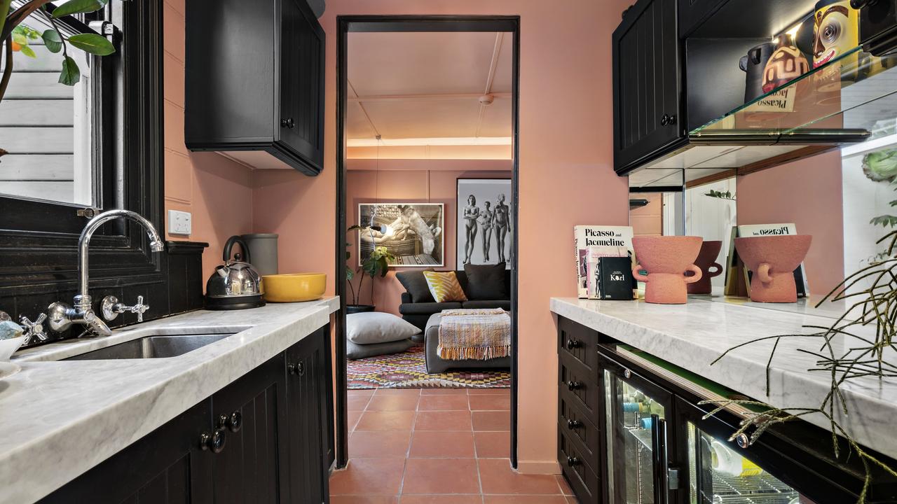 The pink kitchenette leading into a living zone.