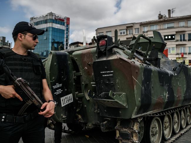 Turkish anti-riot police officers stand next to an armed vehicle at Taksim square in Istanbul. Picture: AFP.