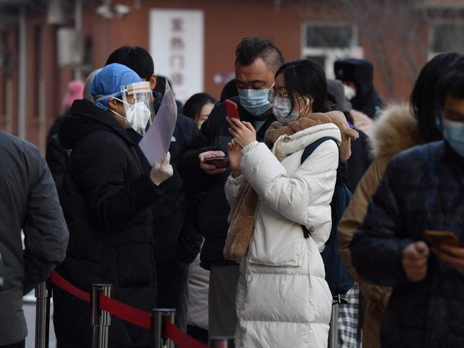 People scan a QR code as they line up for a Covid test in Beijing. Picture: AFP