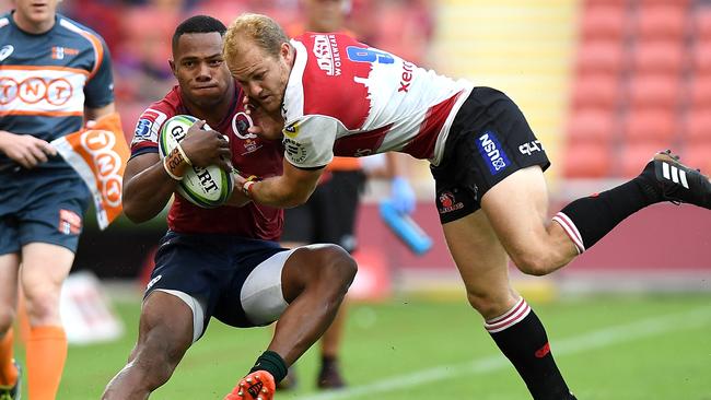 The Reds’ Filipo Daugunu of the Reds tries to beat the Lions’ Dillon Smit on Saturday.