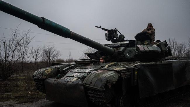 Ukranian servicemen drive a T-64 tank along a road to Bakhmut. Picture: AFP