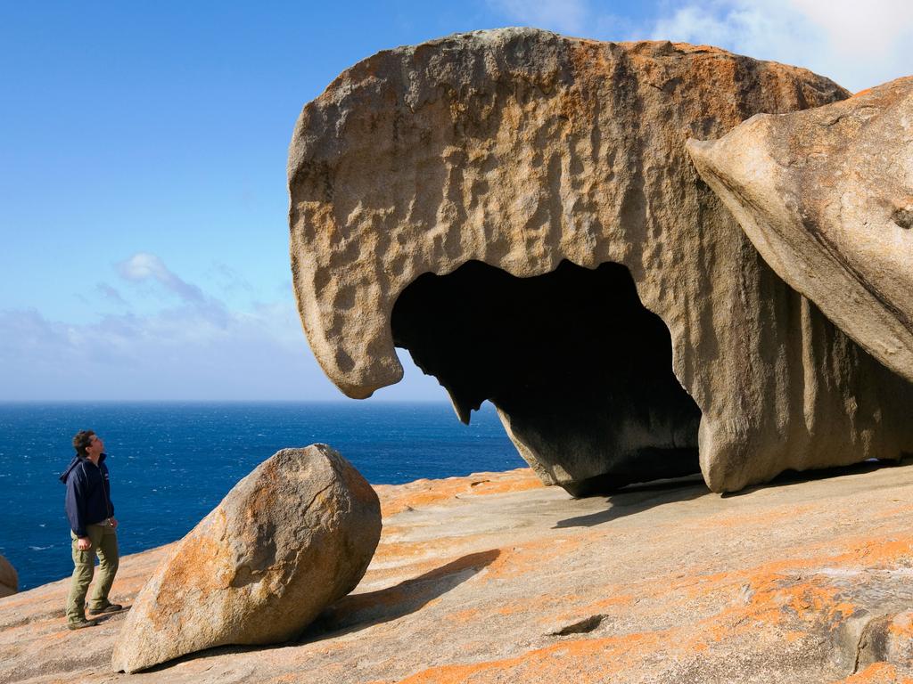 It’s not just wildlife that’s fascinating at Kangaroo Island. A hiker looks at the wind eroded Remarkable Rocks in Flinders Chase at the west end of the island. Picture: Supplied