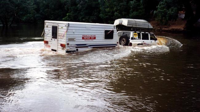 Adventurer Frank Thompson tows a caravan across the flooded Wenlock River during production of video on Cape York in 1997.