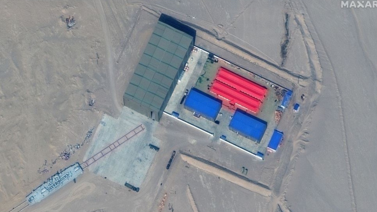 A Chinese testing facility with a scale replica of a US Navy amphibious assault ship, bottom left, placed on a rail system to provide a moving target for missile targeting. Source: Maxar Technologies.