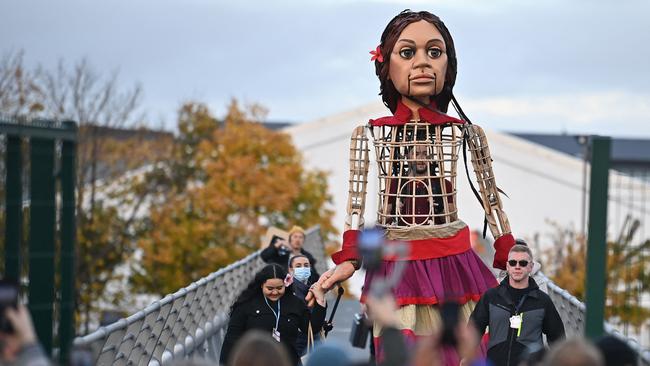 Little Amal, a giant puppet depicting a Syrian refugee girl, strides over the Millennium Bridge after a journey across the Clyde with young activists at the COP26 UN Climate Change Conference in Glasgow. Picture: AFP