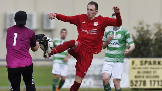 Whittlesea United’s Reis Aygun tries to pip Corio’s goalkeeper to the ball. Picture: Alan Barber