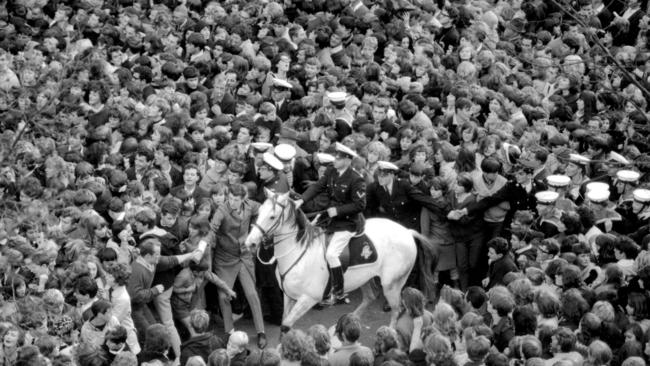 The mounted policeman faces a hopeless task trying to control 10,000 people, most of them teenagers, who flooded Exhibition St in June 1964 to catch a glimpse of The Beatles at the Southern Cross Hotel.