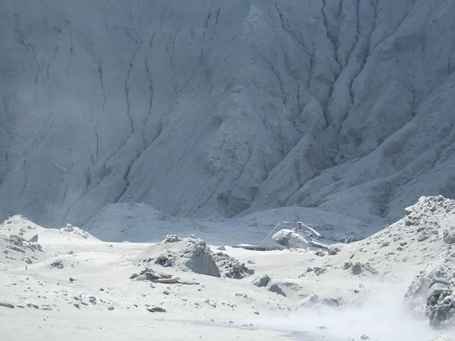 This handout photograph courtesy of Michael Schade shows wreckage of a helicopter amid ash minutes after the volcano on New Zealand's White Island erupted. Picture: AFP