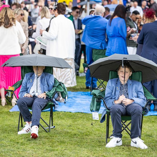 Two young fans prepare for the rain to hit. Picture: Jake Nowakowski