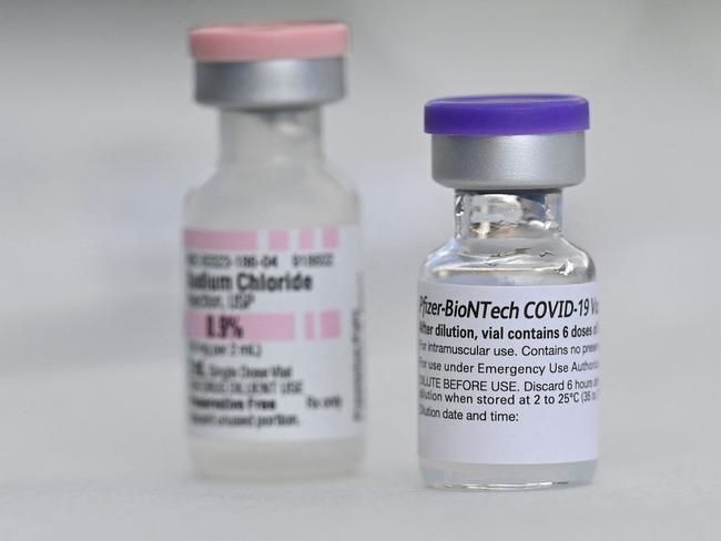 (FILES) In this file photo taken on August 11, 2021 Vials of Pfizer Covid-19 vaccine and sodium cloride (used for dilution of the vaccine) are seen  at a community vaccination event in a predominately Latino  neighborhood in Los Angeles, California. - The United States on September 22, 2021 authorized the use of boosters of Pfizer's Covid-19 vaccine for people aged over 65, people at high-risk of severe disease and those in high-exposure settings to the virus. (Photo by Robyn Beck / AFP)