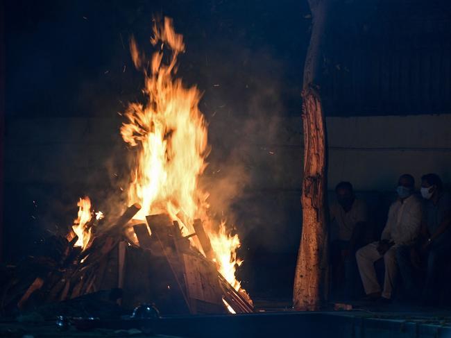 Relatives watch the cremation of a loved one at Nigambodh Ghat Crematorium in New Delh. Picture: AFP