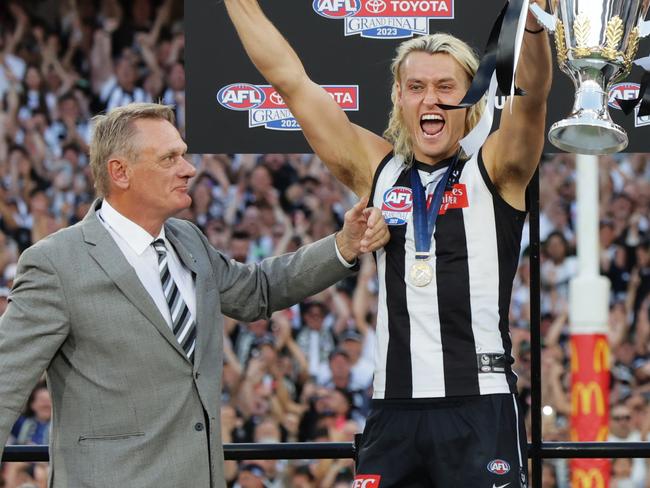 Peter Moore presents the premiership cup to Darcy on a day the family’s grand final fortune changed. Picture: Lachie Millard