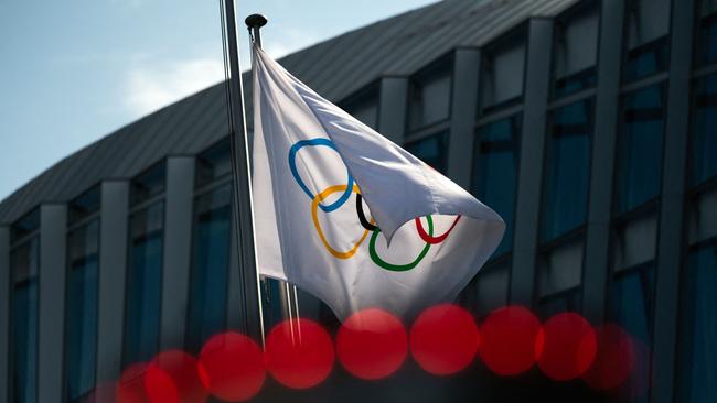 (FILES) This file photo taken on March 8, 2021 shows the Olympic flag floating next to the headquarters of the International Olympic Committee (IOC) in Lausanne. - Ukrainian Presidential aide Mykhaylo Podolyak on January 30, 2023 called the International Olympic Committee (IOC) a "promoter of war" after the sports body said it was considering ways for Russian athletes to compete. (Photo by Fabrice COFFRINI / AFP)