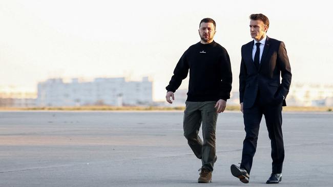 France's President Emmanuel Macron, right, and Ukrainian President Volodymyr Zelensky walk on the tarmac of Velizy-Villacoublay air base.