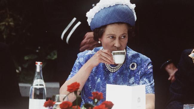 Queen Elizabeth II enjoys a cup of tea during a royal visit to Northern Ireland in 1977. Picture: Anwar Hussein/Getty Images