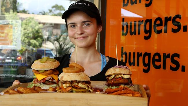 Just Poppy's at Riverhills is ranked in the top 10 for burgers in Brisbane area, pictured is Tahlia Piccirillo with Collective Burger, Tree Hugger Burger and Halloween Burger, Riverhills Friday. Picture AAP/David Clark