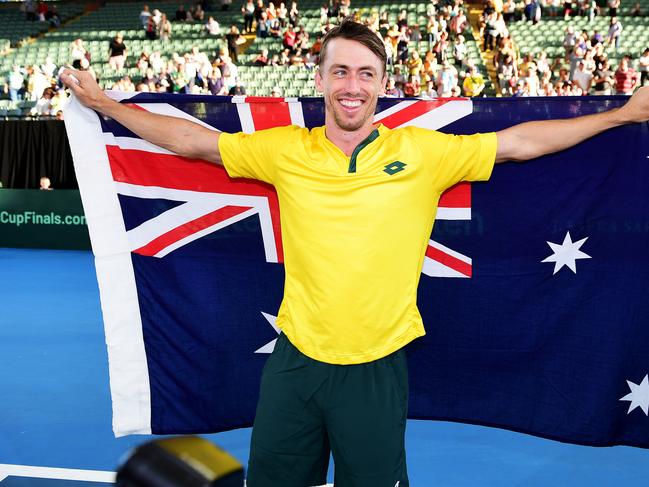 ADELAIDE, AUSTRALIA - MARCH 07: John Millman of Australia celebrates with the Australian flag after  the Davis Cup Qualifier singles match between John Millman of Australia  and Thiago Monteiro of Brazil   at Memorial Drive on March 07, 2020 in Adelaide, Australia. (Photo by Mark Brake/Getty Images)