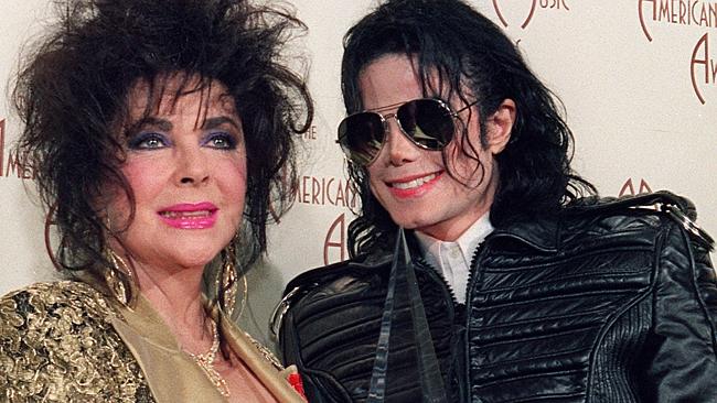 US Actress Elizabeth Taylor (L) with singer and performer Michael Jackson hold on one of two awards he won January 25, 1993 a...