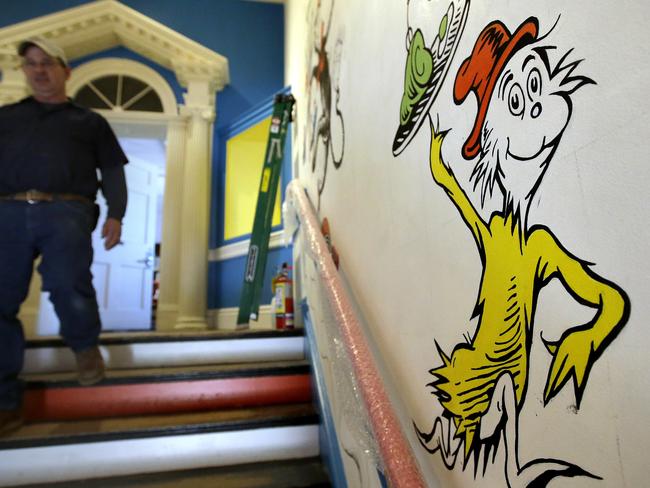 In this May 4, 2017, photo a man walks past a mural with the character "Sam-I-Am" from the Dr. Seuss book "Green Eggs and Ham" at The Amazing World of Dr. Seuss Museum, in Springfield, Mass. The museum opened on June 3 in his hometown. (AP Photo/Steven Senne)