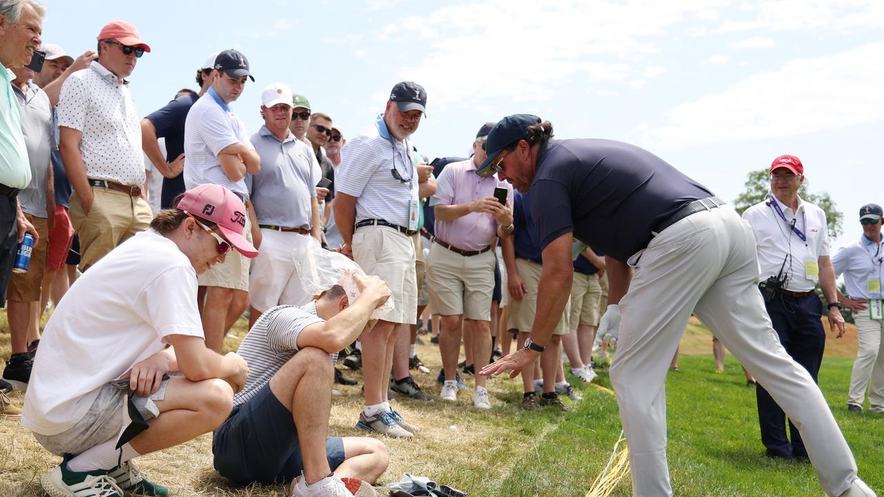 Phil Mickelson gives his golf glove to a fan that was hit by his errant drive. (Photo by Patrick Smith/Getty Images)