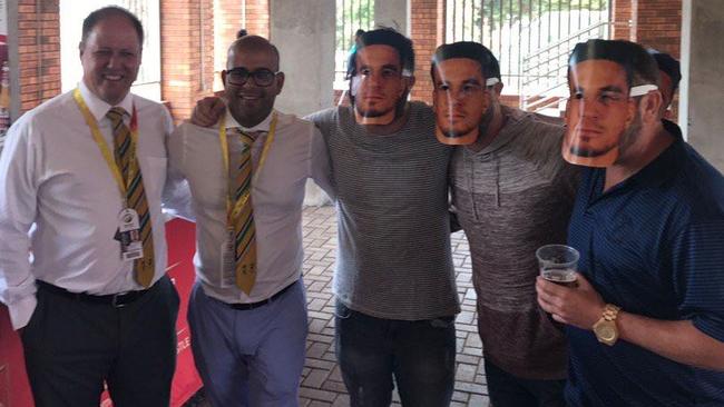 South African cricket officials Clive Eksteen (left) and Altaaf Kazi (second from left) pose with fans wearing Sonny Bill Williams masks, a slur against David Warner's wife Candice.