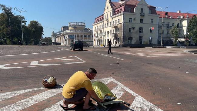 A man next to the body of a person at the site of a missile strike in the centre of Chernihiv. Picture: National Police of Ukraine / AFP