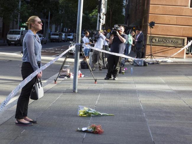 Kate Golder was in tears as she delivered flowers to the scene in Martin Place. Picture by: Kate Dwek / Splash News