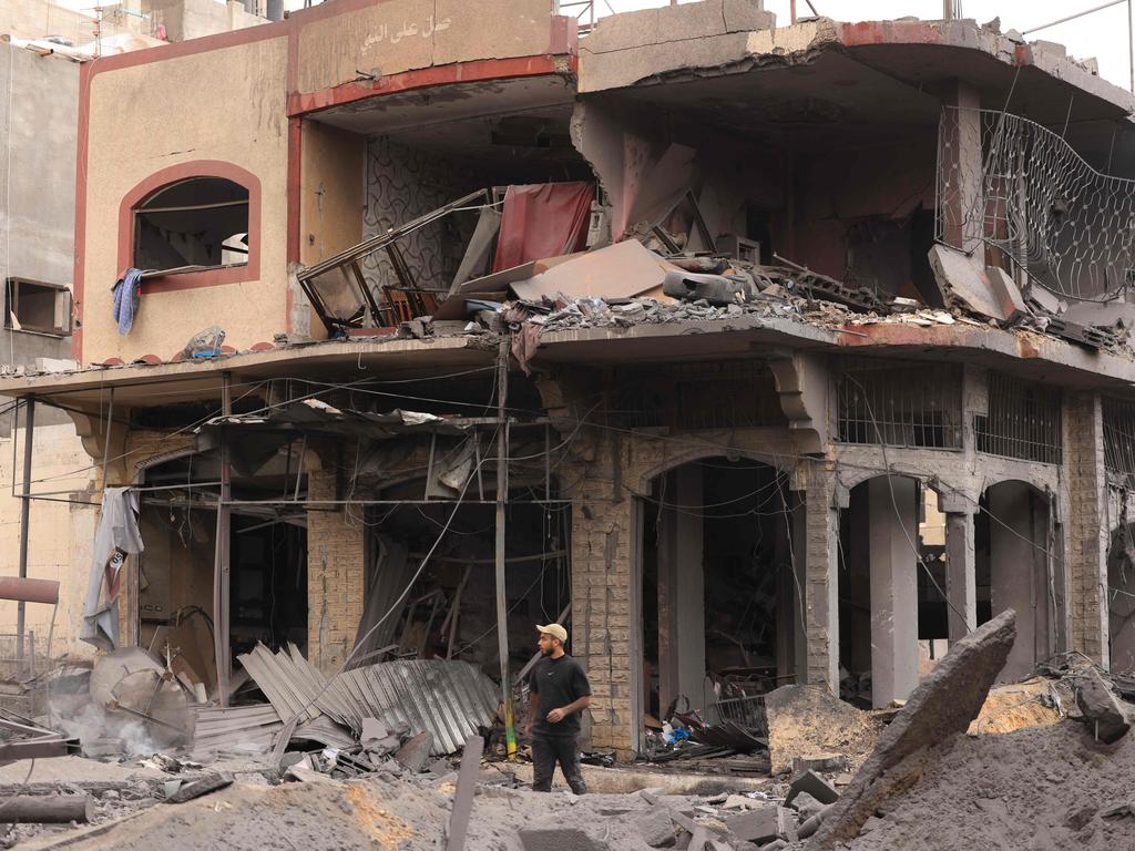 A young Palestinian walks through rubble in a heavily bombarded neighbourhood.