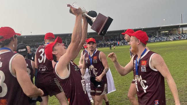 Melton player Harrison Hanley lifts the premiership cup. Picture: Shane Jones.