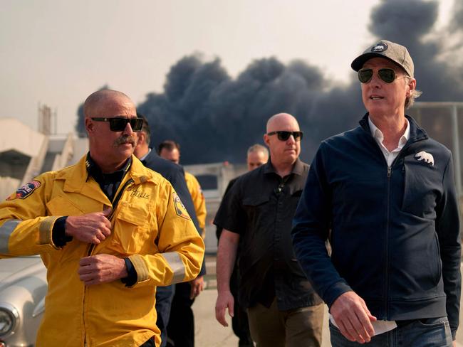 LOS ANGELES, CALIFORNIA - JANUARY 8: California Governor Gavin Newsom (R) tours the downtown business district of Pacific Palisades as the Palisades Fire continues to burn on January 8, 2025 in Los Angeles, California. Fueled by intense Santa Ana Winds, the Palisades Fire has grown to over 2,900 acres and 30,000 people have been ordered to evacuate while a second major fire continues to burn near Eaton Canyon in Altadena.   Eric Thayer/Getty Images/AFP (Photo by Eric Thayer / GETTY IMAGES NORTH AMERICA / Getty Images via AFP)