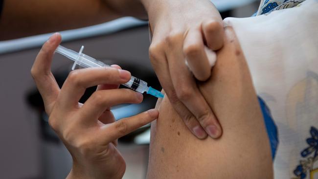 A healthcare worker gives a dose of the vaccine.