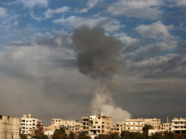 Smoke rises from buildings in Kafr Batna following Syrian government bombardments on the besieged Eastern Ghouta region on the outskirts of the capital Damascus on February 21, 2018.  / AFP PHOTO / Amer ALMOHIBANY