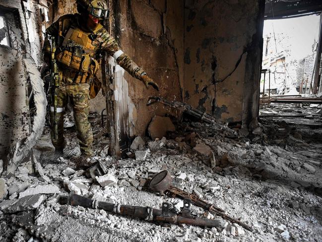 A Russian soldier collects weapons found while patrolling at the Mariupol drama theatre, hit last March 16 by an airstrike. Picture: AFP