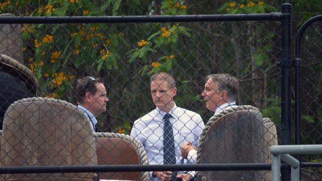 Police detectives are seen behind one of the rafts from the Thunder River Rapids ride at the Dreamworld theme park on the Gold Coast, Tuesday, Nov. 1, 2016. (AAP Image/Ed Jackson) NO