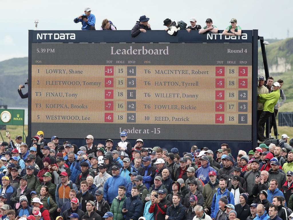 Spectators clamber on to and on top of a scoreboard as they vie to get a glimpse of Ireland's Shane Lowry. (AP Photo/Peter Morrison)