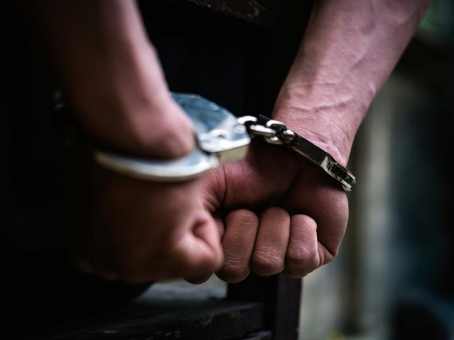 Man on the chair in Handcuffs. Rear view and Closeup ,Men criminal in handcuffs arrested for crimes. With hands in back,boy  prison shackle in the jail violence concept.