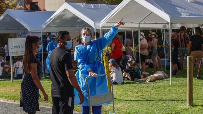 A health worker directs people wanting to be tested for Covid-19 to the end of the queue at Royal Perth Hospital. Picture: Trevor Collens.